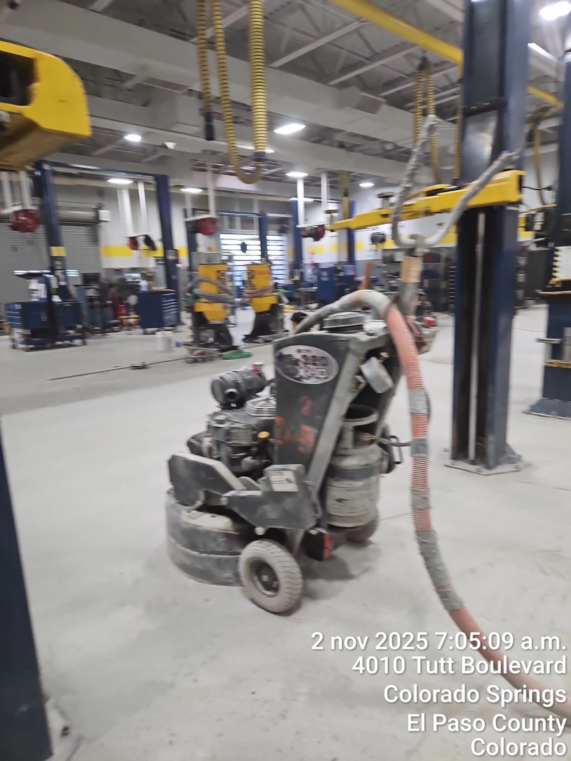 Planetary grinder staged in an auto service bay in Colorado Springs, with a date and location stamp from the crew's field documentation