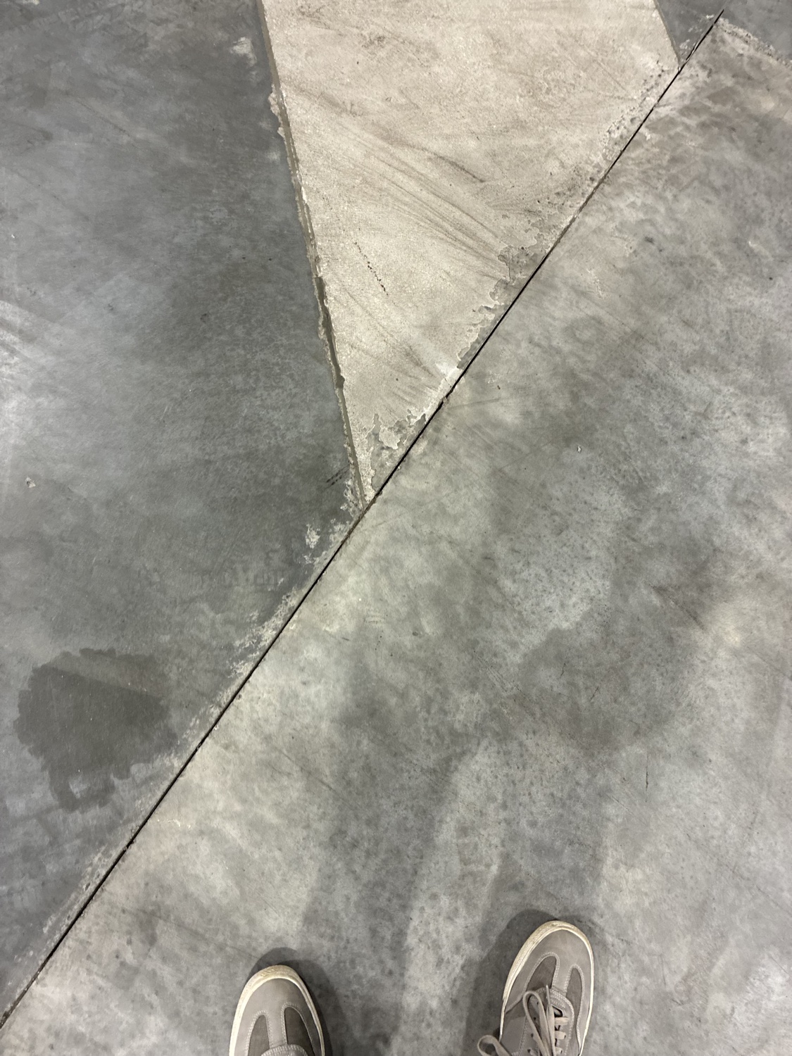 Overhead view of a delaminated floor surface peeling away from the slab