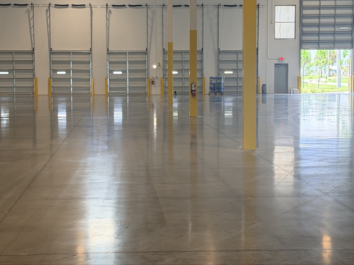 Finished concrete floor lit by daylight through dock doors