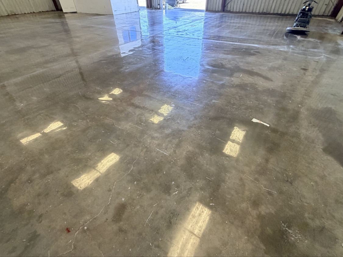 Wide view of a glossy finished floor across a metal building interior