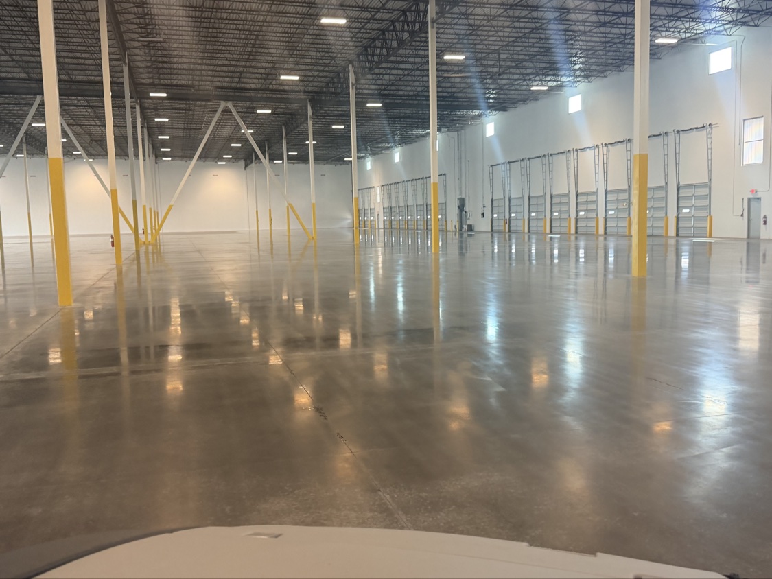 Low-angle view across a mirror-finished concrete floor