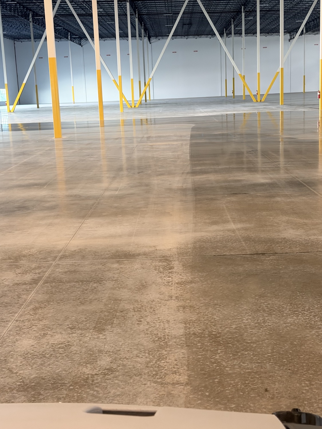 Portrait view of a polished concrete floor transition in a finished warehouse
