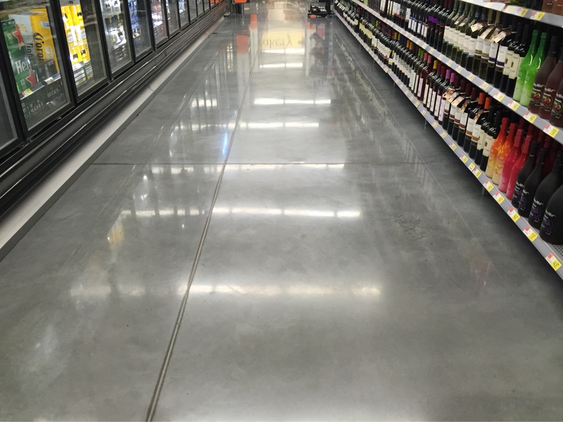 Smooth gray polished concrete floor down a grocery wine aisle