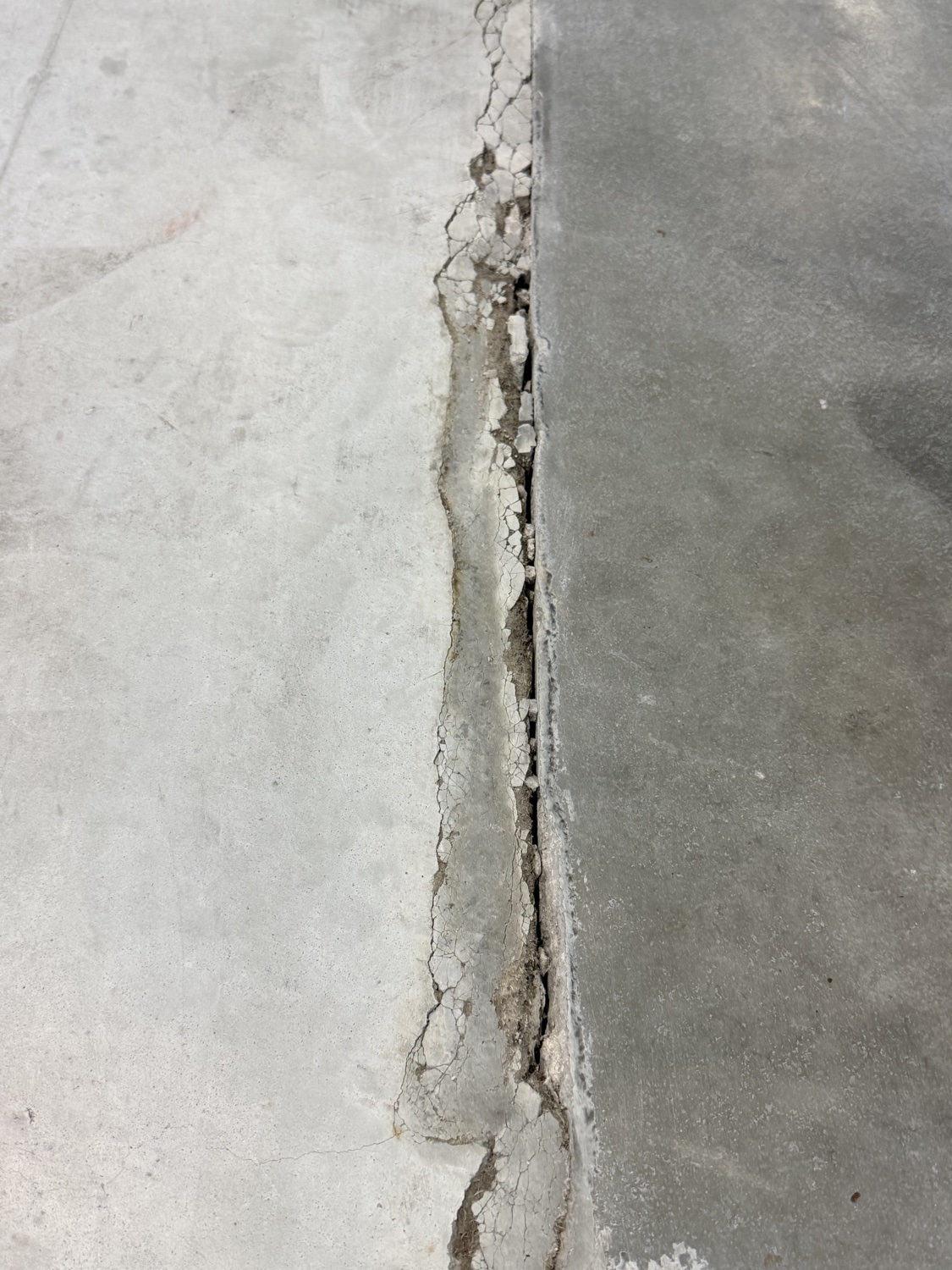 Spalled concrete edge along a failed joint